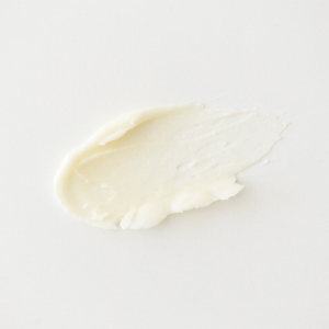 Close-up of a smear of white cream on a light gray background