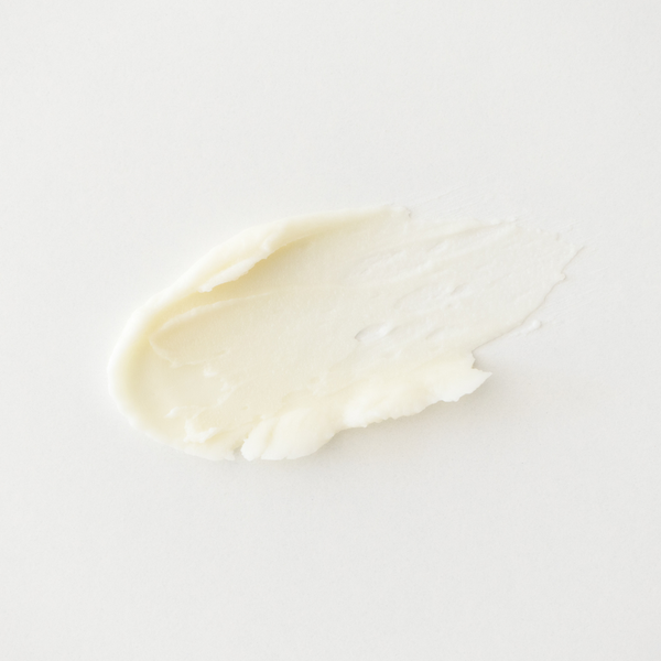 Close-up of a smear of white cream on a light gray background