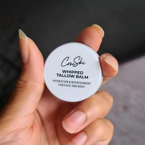 Customer hand holding a sample container of Cow Ski Whipped Tallow Balm 