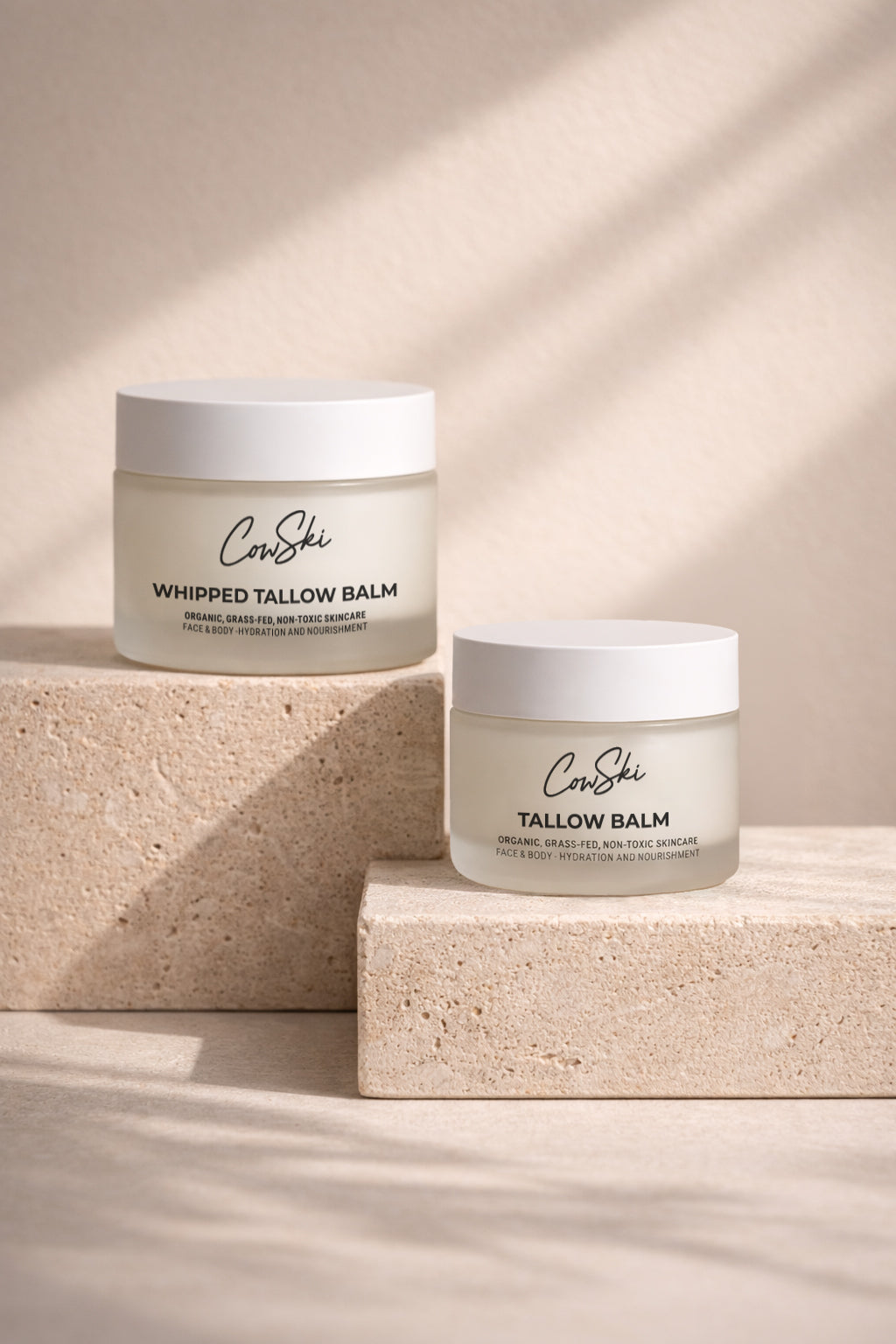 Two jars of CowSki balm on a neutral background